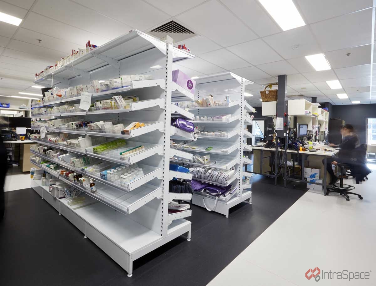 A healthcare facility dispensary counter with organised medicine shelving